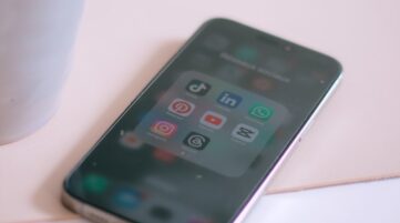 a cup of coffee next to a cell phone